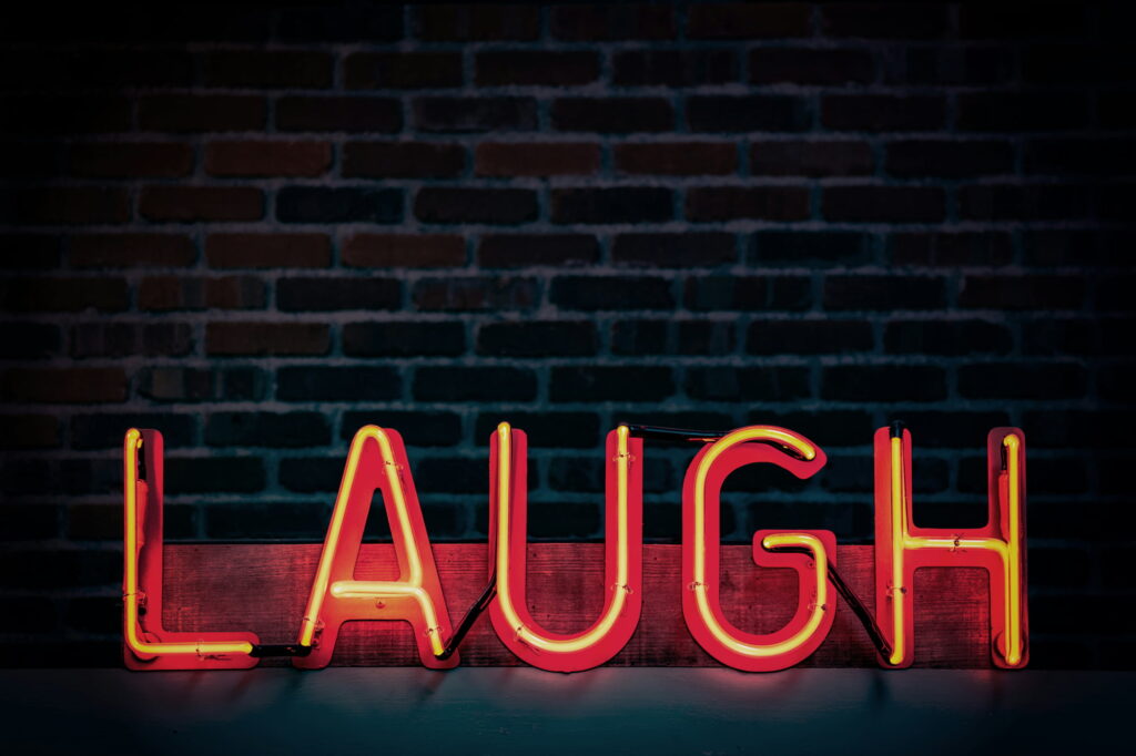 LAUGH écrit en néon rouge